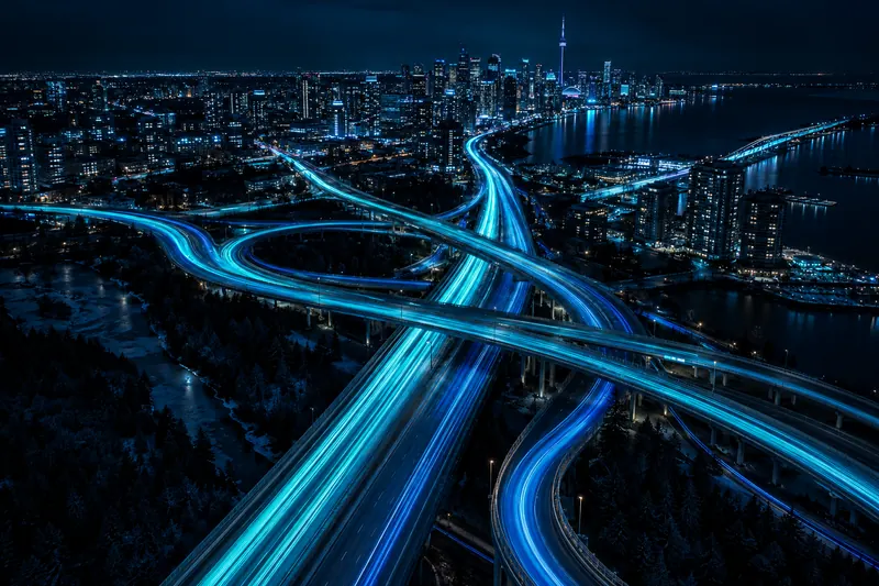 Light trails flowing across a highway interchange at night